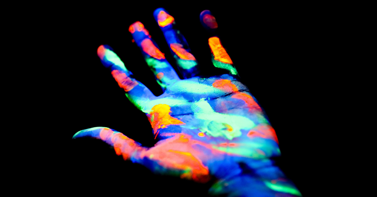 The hand of creativity is covered in neon paint